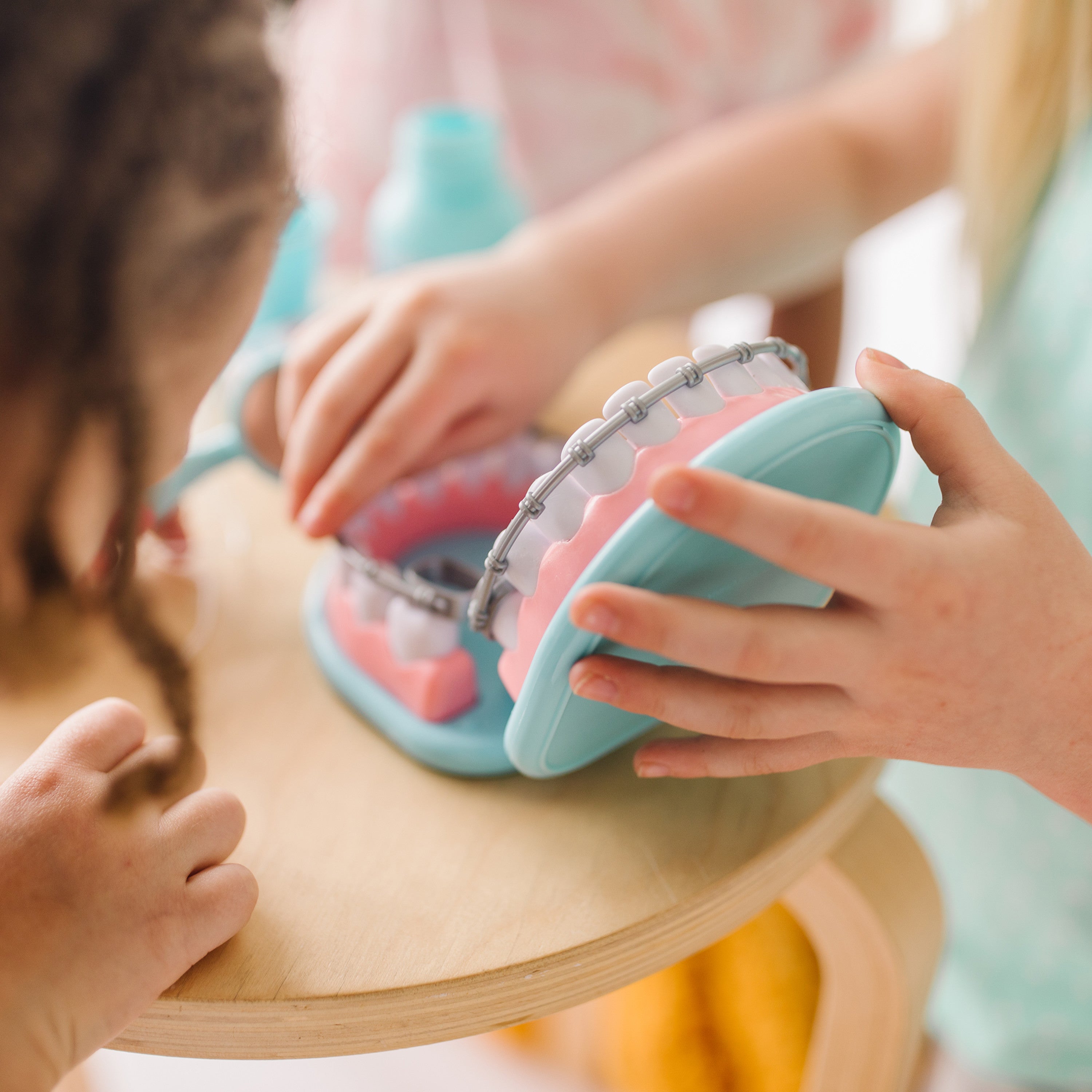 Kids role-playing as a dentist using pretend teeth and cavity stickers
