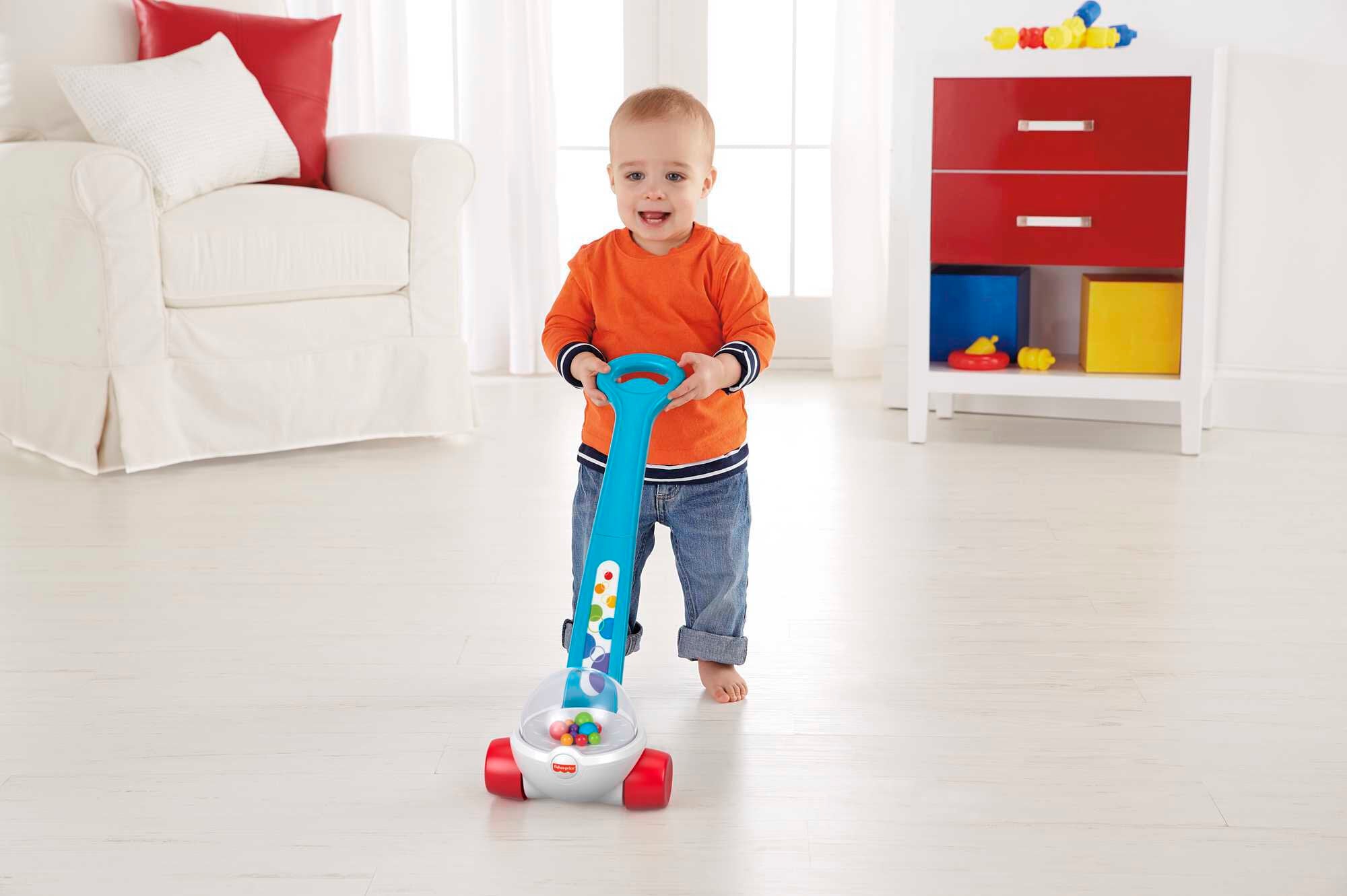 Toddler pushing Fisher-Price Corn Popper with bright balls popping inside
