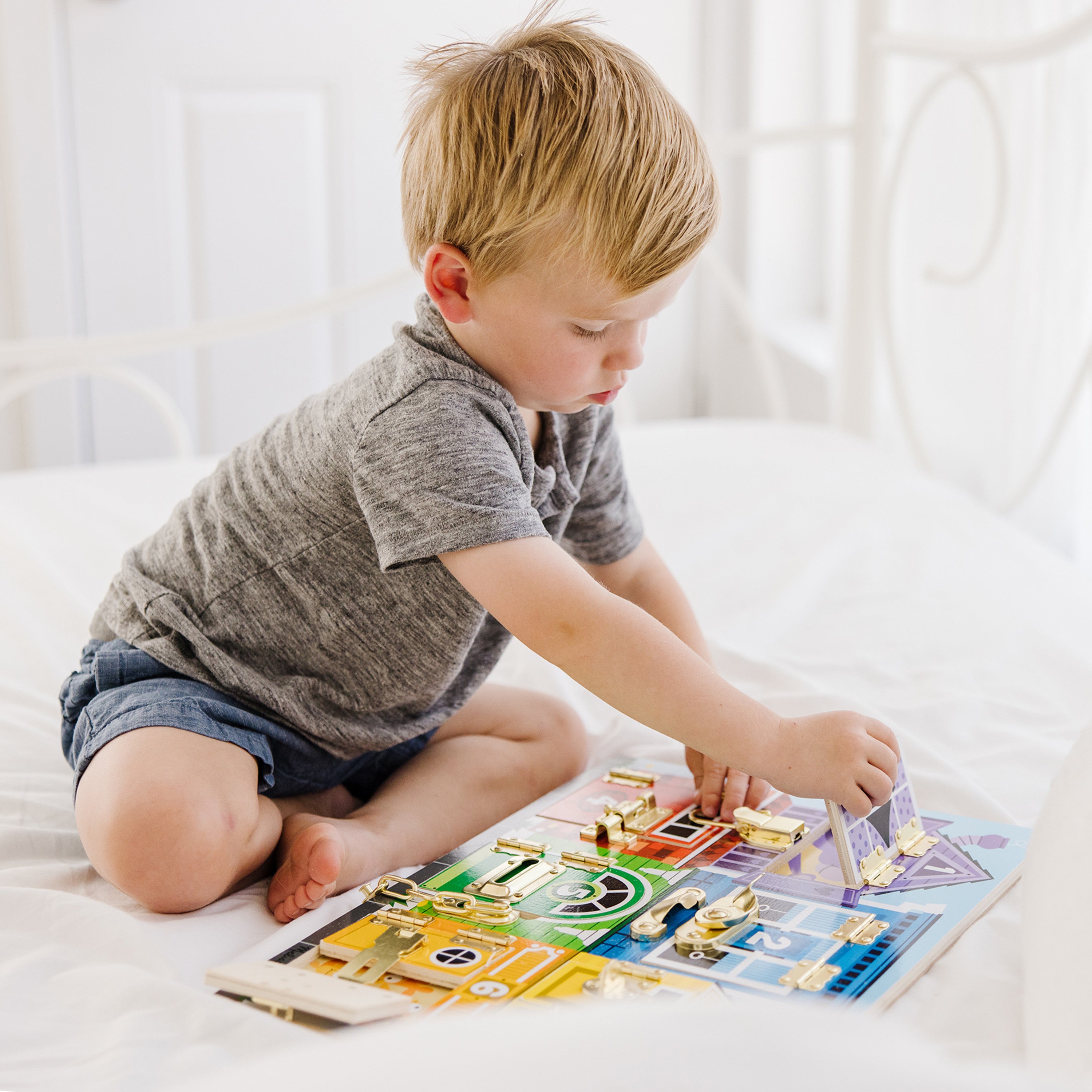 Hands opening a door on the Melissa & Doug latches board
