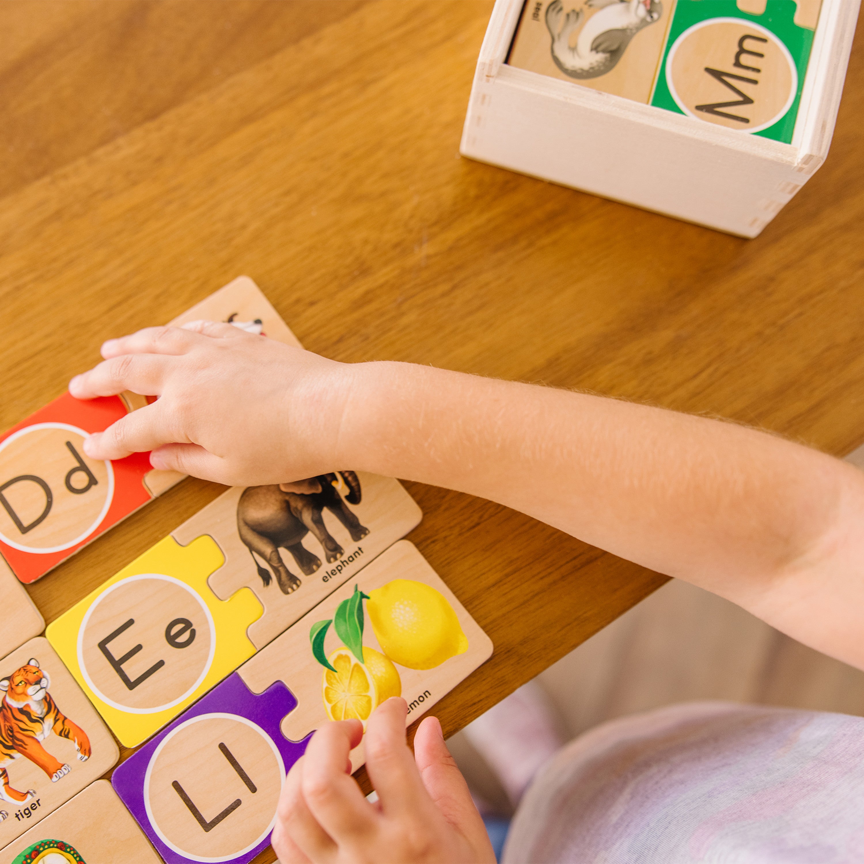 Kids playing with Melissa and Doug alphabet puzzle
