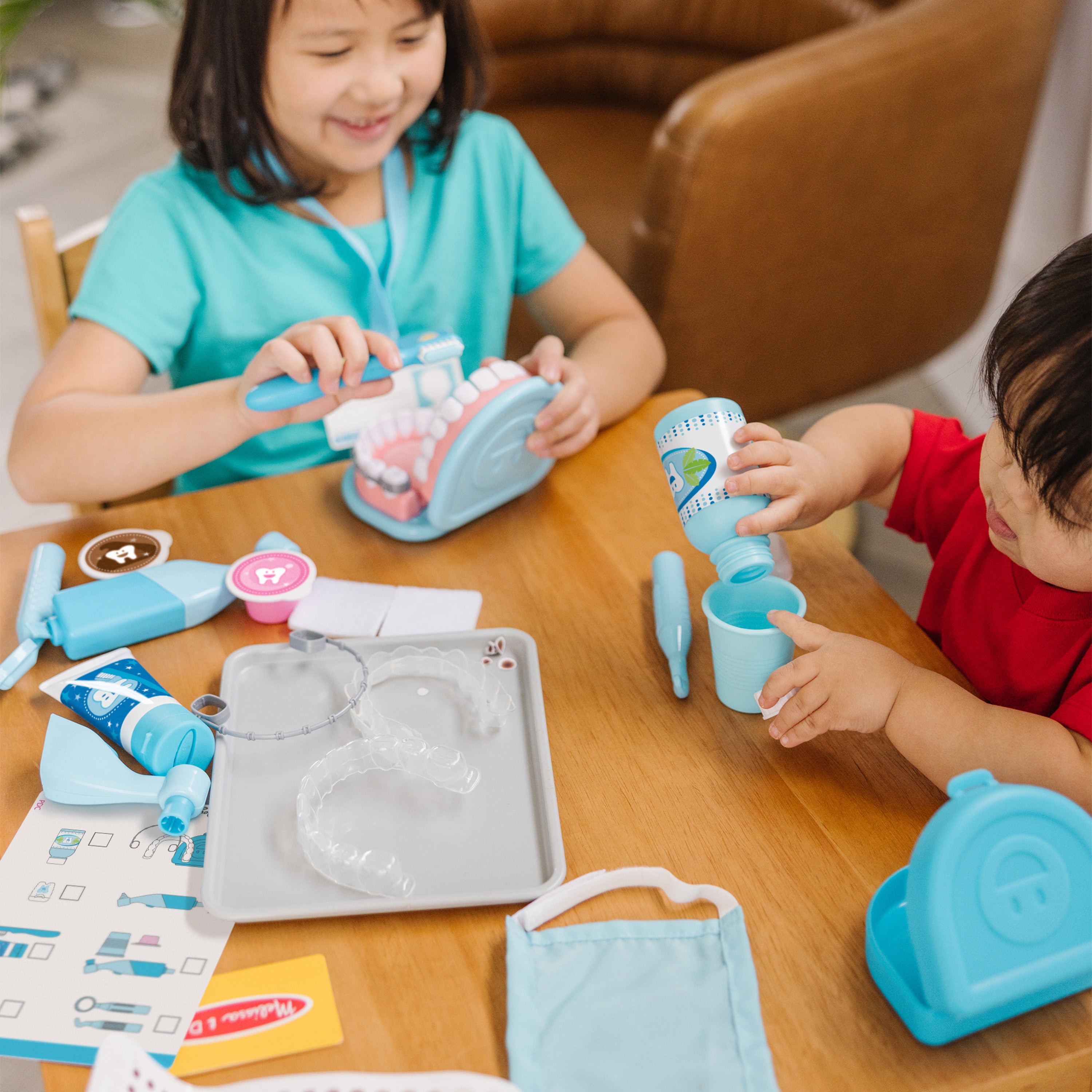 Child using the Melissa & Doug dental kit to practice cleaning pretend teeth
